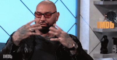 A Bald Man Wearing Sunglasses And A Leather Jacket Is Sitting In Front Of An Imdb Logo GIF