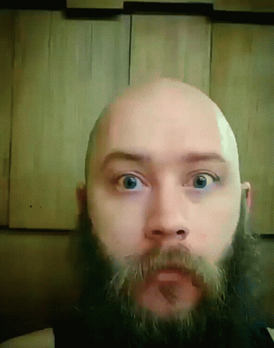 A Bald Man With A Beard And Mustache Is Looking At The Camera GIF