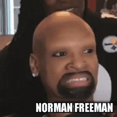 A Bald Man With A Beard And The Name Norman Freeman On The Bottom Right GIF