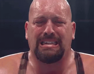 A Bald Man With A Beard Is Crying With His Eyes Closed In A Boxing Ring . GIF