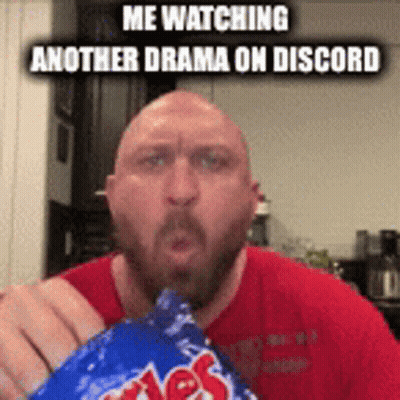 A Bald Man With A Beard Is Eating A Bag Of Doritos . GIF
