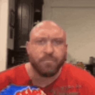 A Bald Man With A Beard Is Eating A Bag Of Doritos . GIF