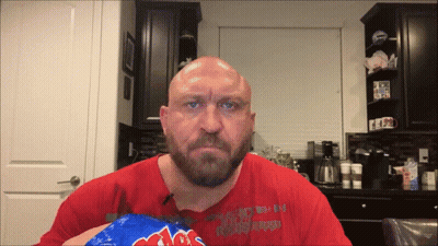 A Bald Man With A Beard Is Holding A Bag Of Mrs. Potato Chips In His Hand GIF