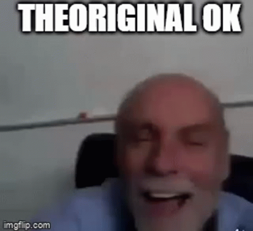 A Bald Man With A Beard Is Laughing With His Eyes Closed And The Words `` The Original Ok '' Written Above Him . GIF