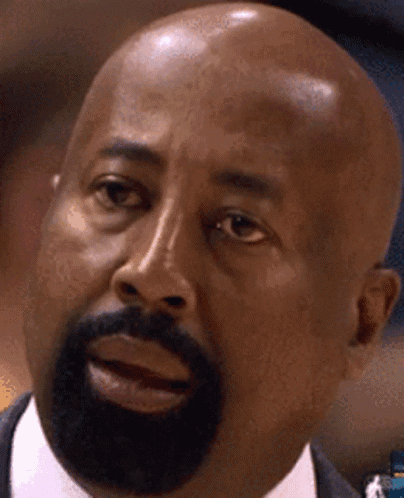 A Bald Man With A Beard Is Looking At The Camera GIF