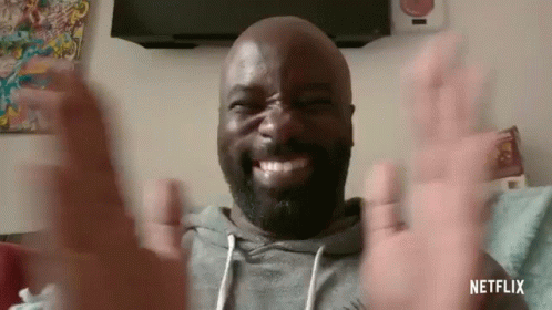 A Bald Man With A Beard Is Making A Funny Face And Waving His Hands . GIF