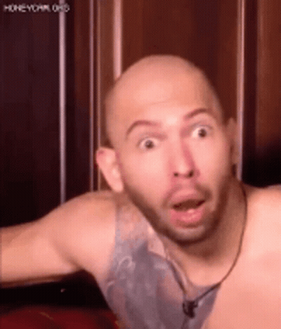 A Bald Man With A Beard Is Making A Funny Face With His Mouth Wide Open . GIF