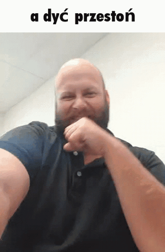 A Bald Man With A Beard Is Making A Funny Face With The Words A Dyc Przeston Behind Him GIF