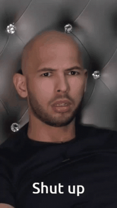 A Bald Man With A Beard Is Sitting In Front Of A Headboard With The Words Shut Up Written On It GIF