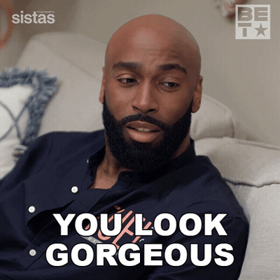 A Bald Man With A Beard Is Sitting On A Couch With The Words You Look Gorgeous Behind Him GIF