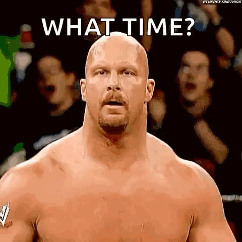 A Bald Man With A Beard Is Standing In Front Of A Crowd And Asking What Time ? GIF