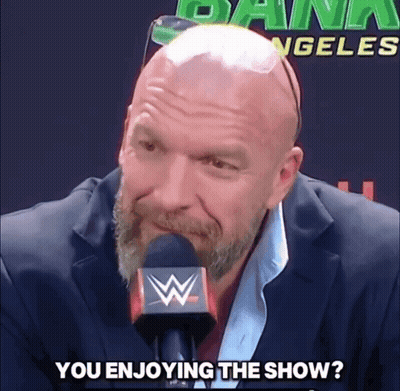 A Bald Man With A Beard Is Talking Into A Microphone With The Words " You Enjoying The Show " Written Below Him GIF