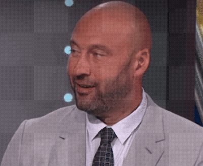 A Bald Man With A Beard Is Wearing A Grey Suit And Tie GIF