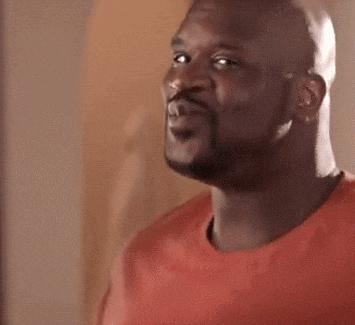 A Bald Man With A Beard Is Wearing A Red Shirt And Looking At The Camera . GIF