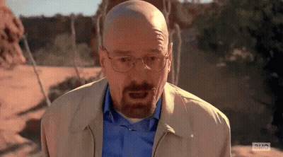 A Bald Man With A Beard Is Wearing Glasses And A Blue Shirt . GIF