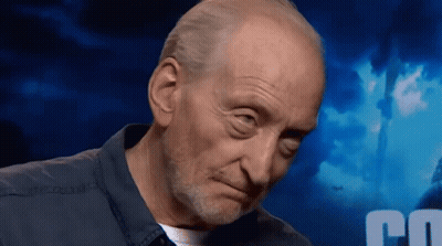 A Bald Man With A Beard Looks At The Camera With A Blue Background With The Letter C On It GIF