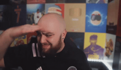 A Bald Man With A Beard Wearing A Black Adidas Shirt Salutes GIF