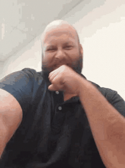 A Bald Man With A Beard Wearing A Black Shirt Is Laughing GIF