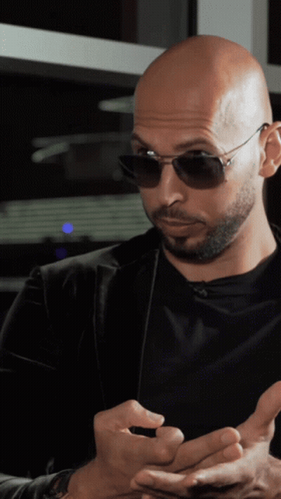 A Bald Man With A Beard Wearing Sunglasses And A Black Shirt GIF