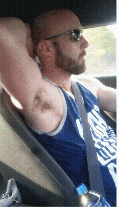 A Bald Man With A Beard Wearing Sunglasses And A Blue Tank Top That Says ' Chicago Bulls ' GIF