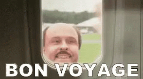A Bald Man With A Mustache Is Looking Out Of An Airplane Window And Smiling . GIF