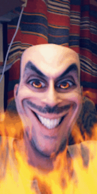A Bald Man With A Mustache Is Smiling With Fire Behind Him GIF