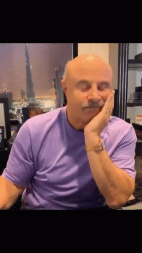 A Bald Man With A Mustache Is Wearing A Purple Shirt GIF