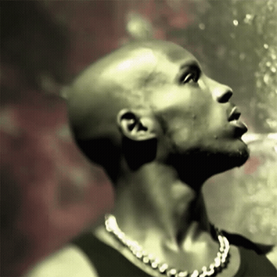 A Bald Man With A Necklace Around His Neck Is Looking Up GIF