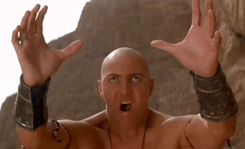 A Bald Man With A Surprised Look On His Face Has His Hands Up In The Air GIF