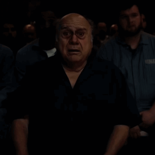 A Bald Man With A Surprised Look On His Face Is Looking At The Camera . GIF