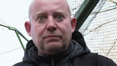 A Bald Man With Blue Eyes And A Beard Wears A Black Jacket GIF