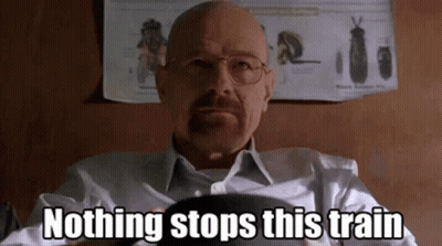 A Bald Man With Glasses And A Beard Is Sitting In Front Of A Poster That Says Nothing Stops This Train . GIF