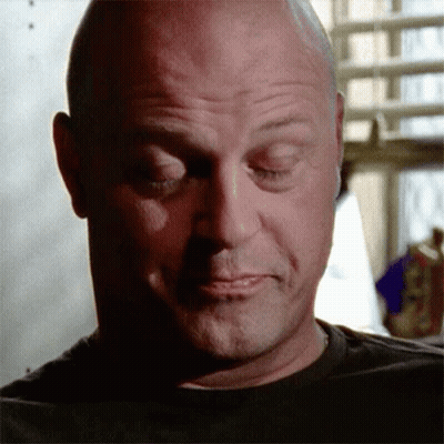 A Bald Man With His Eyes Closed Is Wearing A Black T-Shirt GIF