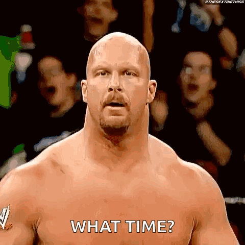 A Bald Wrestler With A Beard Is Standing In Front Of A Crowd And Asking What Time . GIF