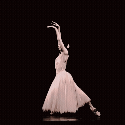 A Ballerina In A White Dress And Pointe Shoes Is Dancing In The Dark GIF