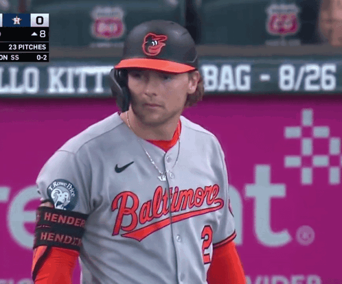 A Baltimore Baseball Player Stands In Front Of A Sign That Says Bag GIF