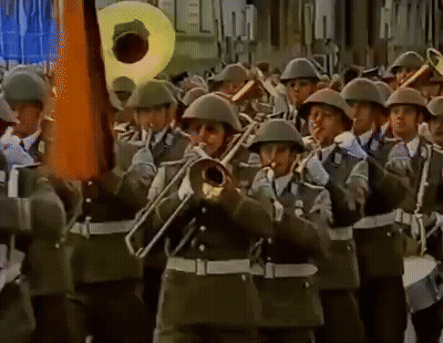 A Band Of Soldiers Marching In A Parade Playing Instruments Including A Trumpet GIF