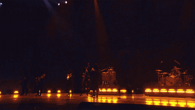 A Band Performing On Stage With A Sign That Says Fuerza Regida GIF