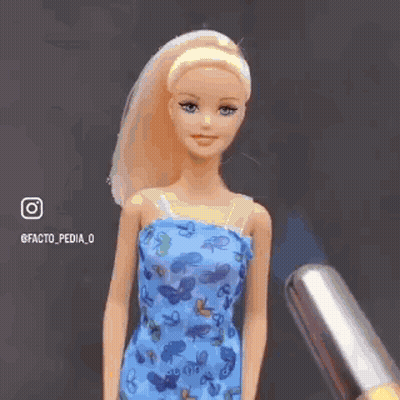 A Barbie Doll With A Burning Head Is Wearing A Blue Dress With Butterflies On It . GIF