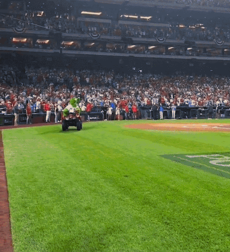 A Baseball Field With A Mascot On A Cart GIF