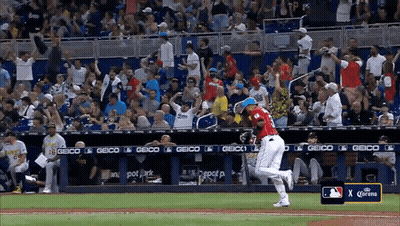 A Baseball Game Is Being Played In Front Of A Crowd And A Sign That Says Corona GIF