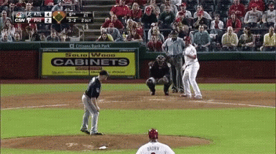 A Baseball Game Is Being Played In Front Of A Sign That Says Cabinets GIF
