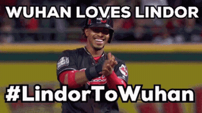 A Baseball Player Applauds While Wearing A Helmet On A Baseball Field GIF