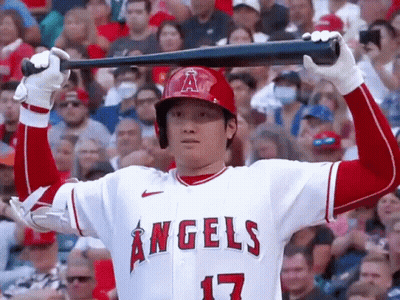 A Baseball Player For The Angels Is Holding A Bat Over His Head In A Crowded Stadium . GIF