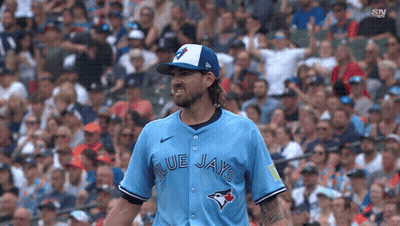 A Baseball Player For The Blue Jays Is Standing In Front Of A Crowd GIF