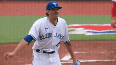 A Baseball Player For The Blue Jays Is Standing On A Field GIF