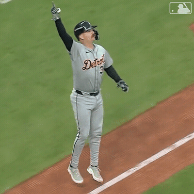A Baseball Player For The Detroit Tigers Is Jumping In The Air With His Arms In The Air GIF