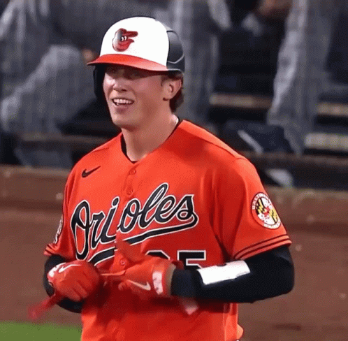 A Baseball Player For The Orioles Is Smiling And Holding His Bat GIF