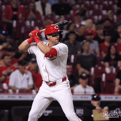 A Baseball Player For The Reds Is Swinging At A Ball GIF