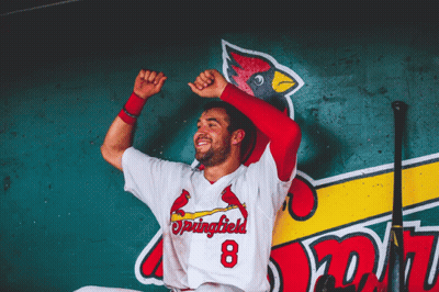 A Baseball Player For The Springfield Cardinals Is Sitting In A Dugout With His Arms In The Air GIF